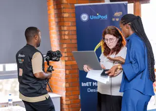 GoodAv Videographer films two women discussing content on a laptop