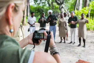 Adult Woman Taking Pictures Of Tented Camp Staff