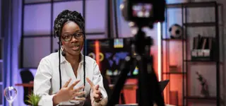 Modern African digital content creator recording video podcast with professional studio camera and lighting in Kigali - GoodAV