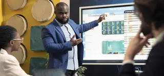 Executive presenting investment data and media market growth opportunities in Africa on high-definition display - GoodAV